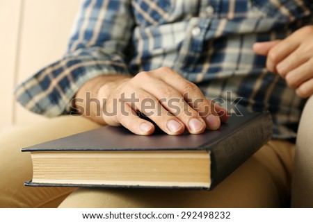 Young man with book on sofa close up