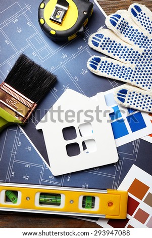 Construction instruments, plan and brushes on house plan background