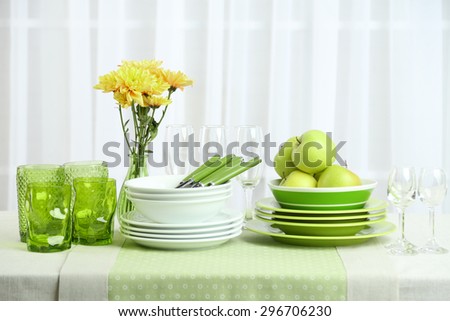 Colorful table settings and tulip flowers in vase on table, on light background