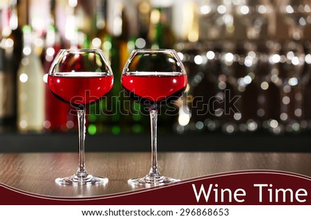Glasses of red wine in bar on blurred background
