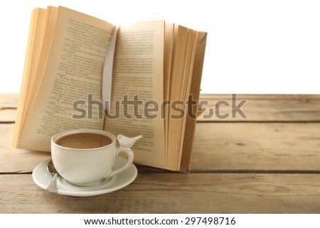 Still life with cup of coffee and book on wooden table, on white background