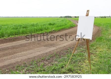 Easel with canvas near country road