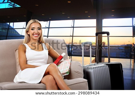 Business woman with suitcase in hall of airport