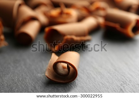 Chocolate curls on wooden table close up