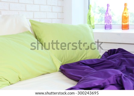 Comfortable bed with pillows and blanket in bedroom