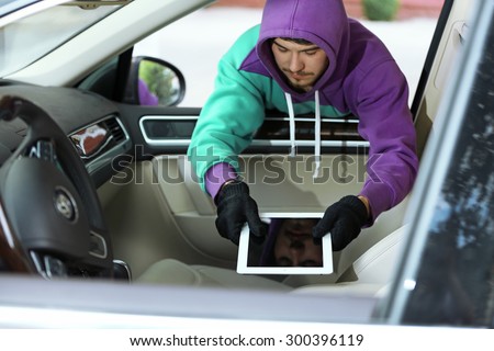 Man burglar steals the tablet of car