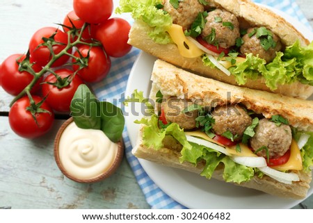 Homemade Spicy Meatball Sub Sandwich on plate, on wooden table background
