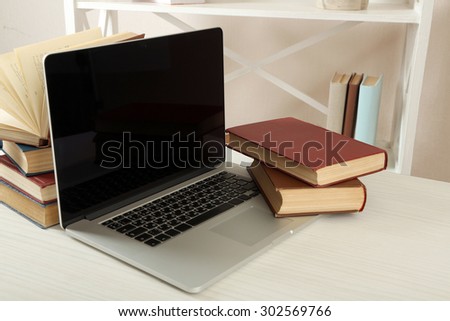 Laptop with books on table close up