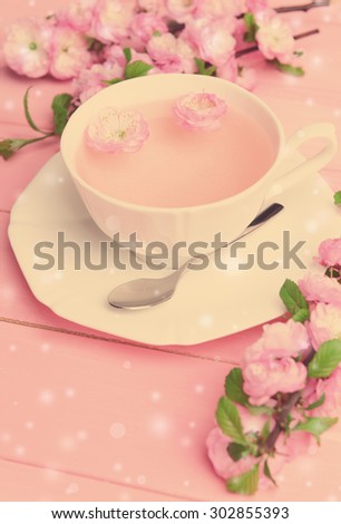 Cup of tea and beautiful fruit blossom on table