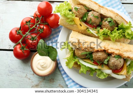 Homemade Spicy Meatball Sub Sandwich on plate, on wooden table background