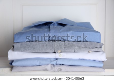 Business shirts on shelf in cupboard