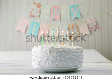 Birthday cake with candles on planks wall background