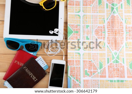 Sunglasses, passports, tickets, PC tablet, close up, on wooden background. Preparing for travel concept