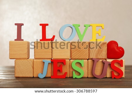 I LOVE JESUS sign illustrated with colorful plastic letters on wooden table on light textured background