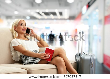 Business woman with suitcase in hall of airport