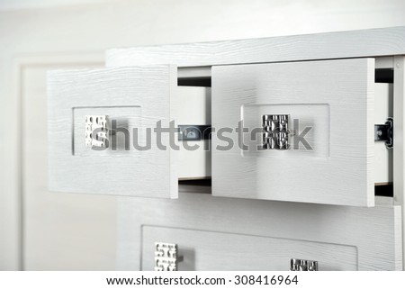 White wooden chest of drawer, close up. Open drawer