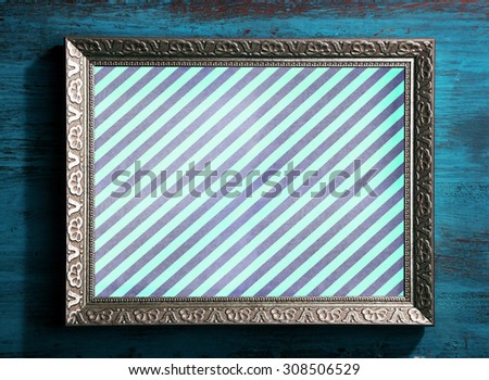 Old frame with striped canvas on wooden background