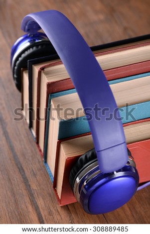 Books and headphones as audio books concept on wooden table, closeup