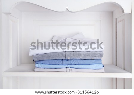 Business shirts on shelf in cupboard