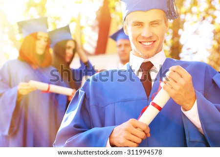 Graduated students in graduation hat and gown, outdoors