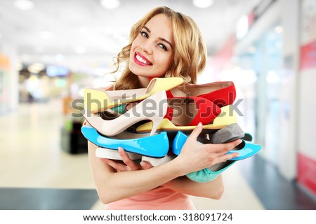 Beautiful young woman with shoes in the mall