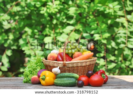 Heap of fresh fruits and vegetables in basket on table outdoors