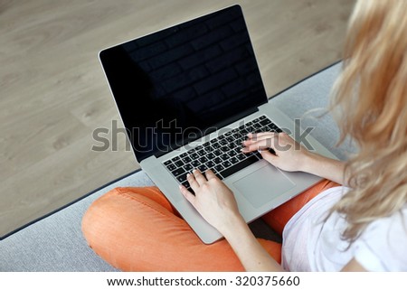 Woman using laptop, indoors