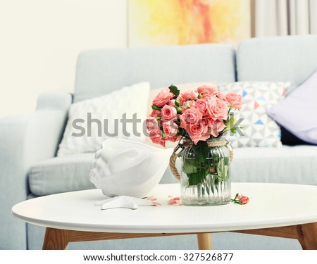 Beautiful rose in vase on table in room