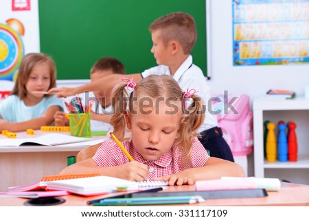 Group of children at the desks in classroom