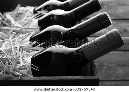 Box with straw and wine bottles,  black and white retro stylization