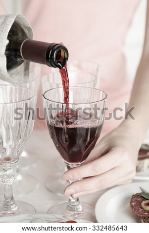 Woman pouring wine into glass,  black and white retro stylization