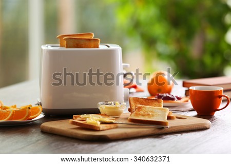 Served table for breakfast with toast, coffee and fruit, on blurred background