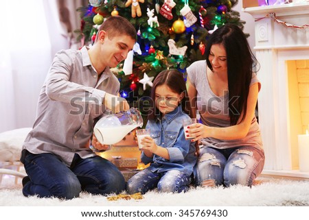 Happy family drink milk in the decorated Christmas room