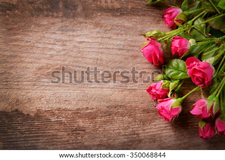 Beautiful bouquet of pink little roses on wooden background, copy space