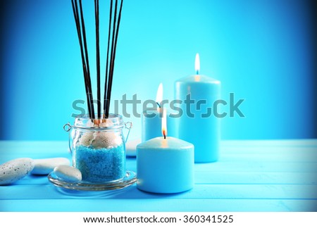 Spa composition of blue candles, stones and sea salt on blue background