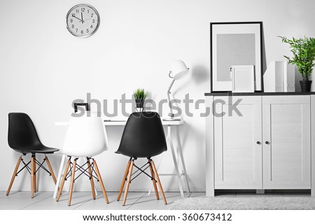 Room interior with commode, frames, chairs and table on white wall background