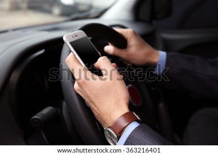 Man driver using smart phone in car