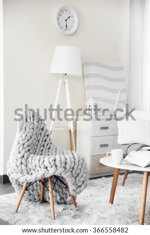Room design with white furniture, picture, clock and floor lamp over beige wall