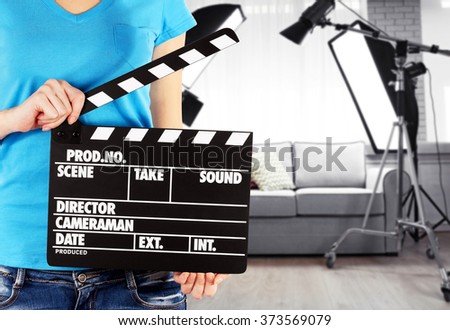 Operator holding clapperboard during the production of film indoors