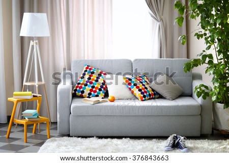 Living room interior with sofa, lamp and green tree