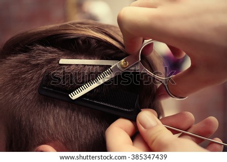 Professional barber making stylish man haircut