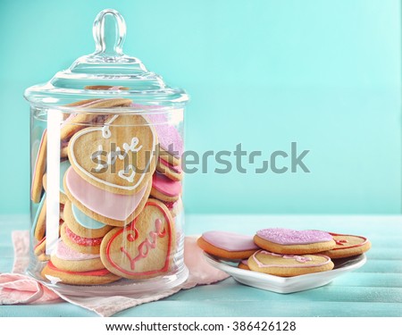 Assortment of love cookies in jar on blue background