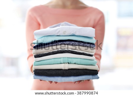 Woman hold clothes pile, close up