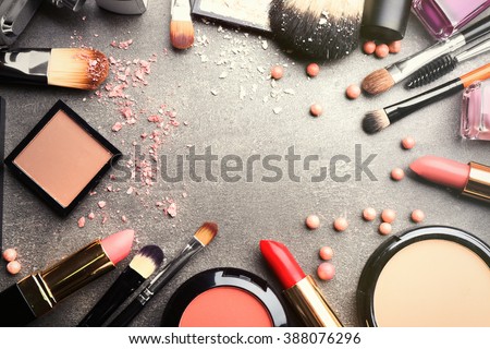 Frame of decorative cosmetics and accessories for makeup on grey background