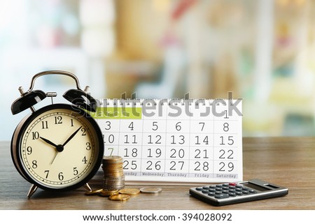 Tax time and alarm clock with coins, calculator and calendar