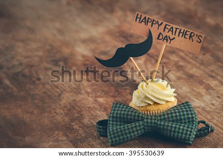 Happy fathers day special cupcake and bow tie on wooden table