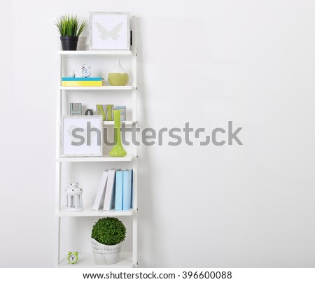 White bookcase with books and accessories in the room