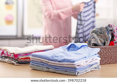 Woman putting together clothes in the room