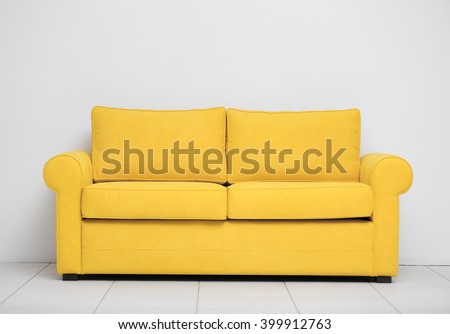 Yellow sofa on white wall background