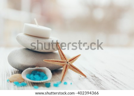 Spa stones with starfish and sea salt on white wooden table